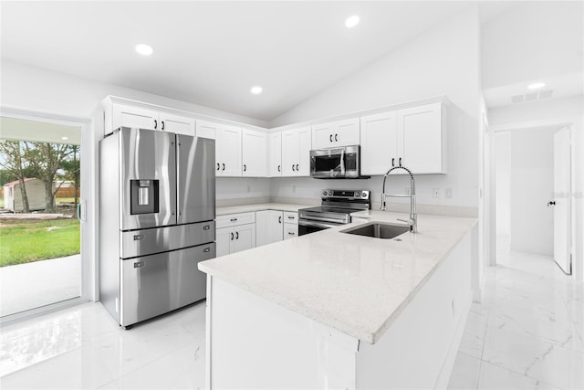 kitchen featuring kitchen peninsula, appliances with stainless steel finishes, light stone counters, sink, and white cabinets