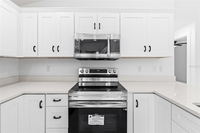 kitchen featuring ceiling fan, white cabinets, light stone counters, and appliances with stainless steel finishes