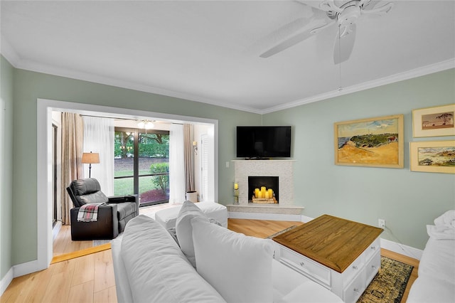 living room featuring ceiling fan, light hardwood / wood-style flooring, and crown molding