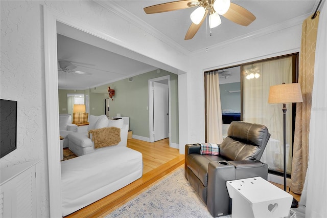 interior space with ceiling fan, ornamental molding, and light hardwood / wood-style floors