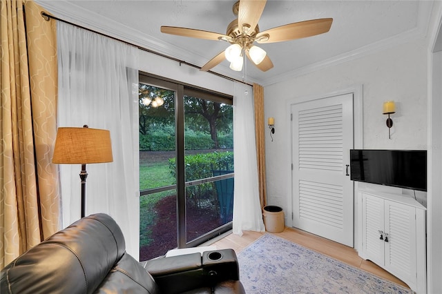 living room featuring crown molding, light hardwood / wood-style floors, and ceiling fan