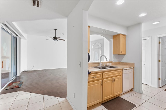 kitchen featuring white dishwasher, sink, light tile patterned floors, and light brown cabinets