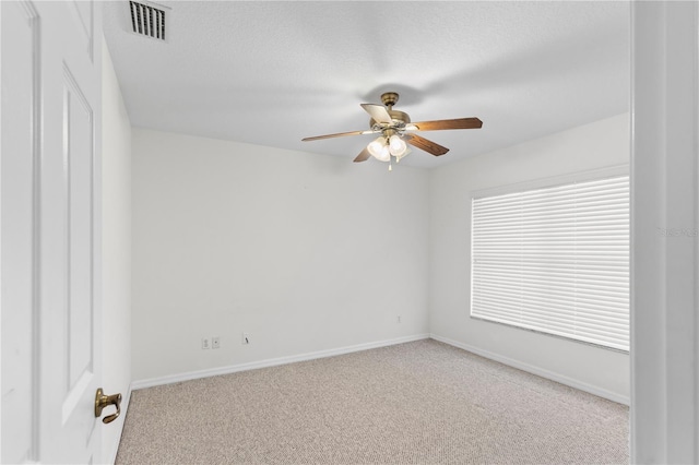 carpeted spare room with a textured ceiling and ceiling fan