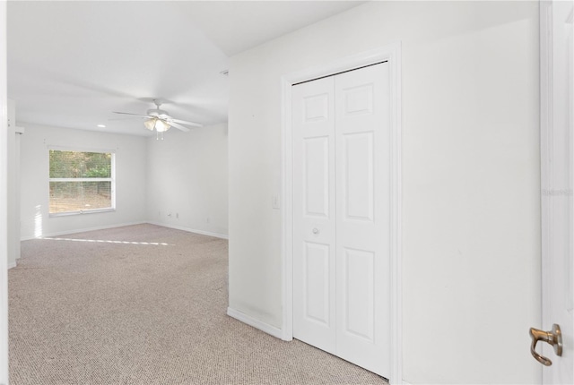 carpeted spare room featuring ceiling fan