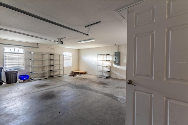 garage with a garage door opener and electric panel