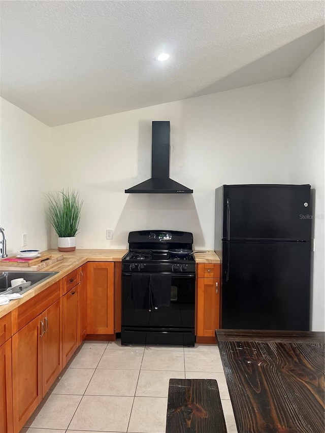 kitchen with sink, light tile patterned floors, black appliances, a textured ceiling, and wall chimney exhaust hood