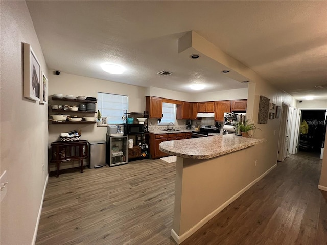 kitchen featuring sink, a textured ceiling, dark hardwood / wood-style flooring, kitchen peninsula, and electric stove