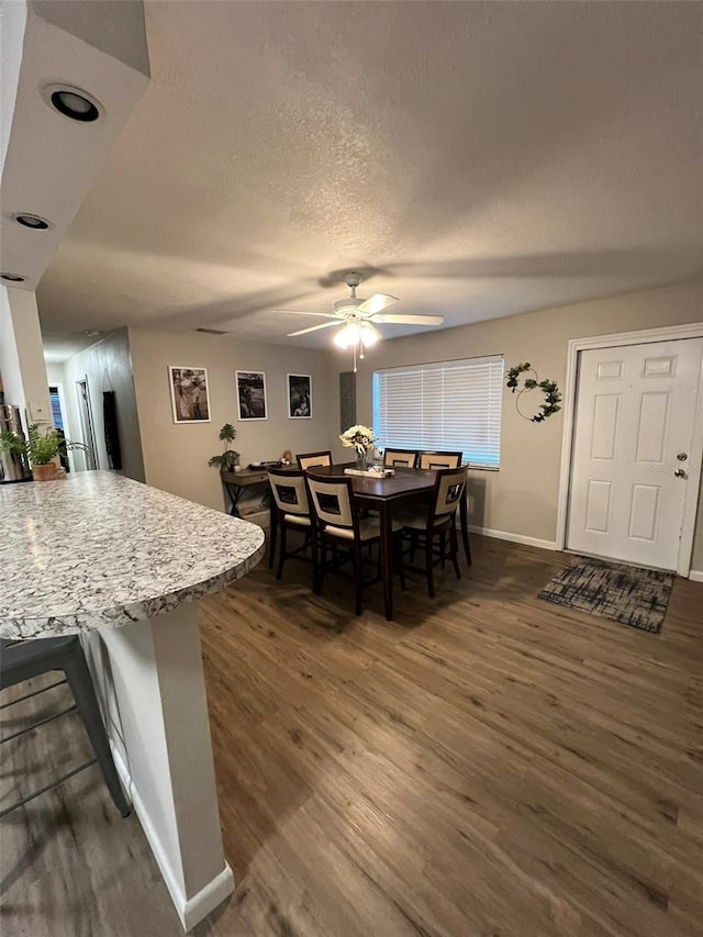 dining space with dark hardwood / wood-style floors, a textured ceiling, and ceiling fan