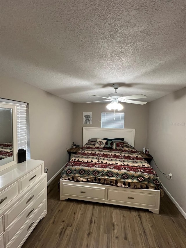 bedroom featuring dark hardwood / wood-style flooring, a textured ceiling, and ceiling fan