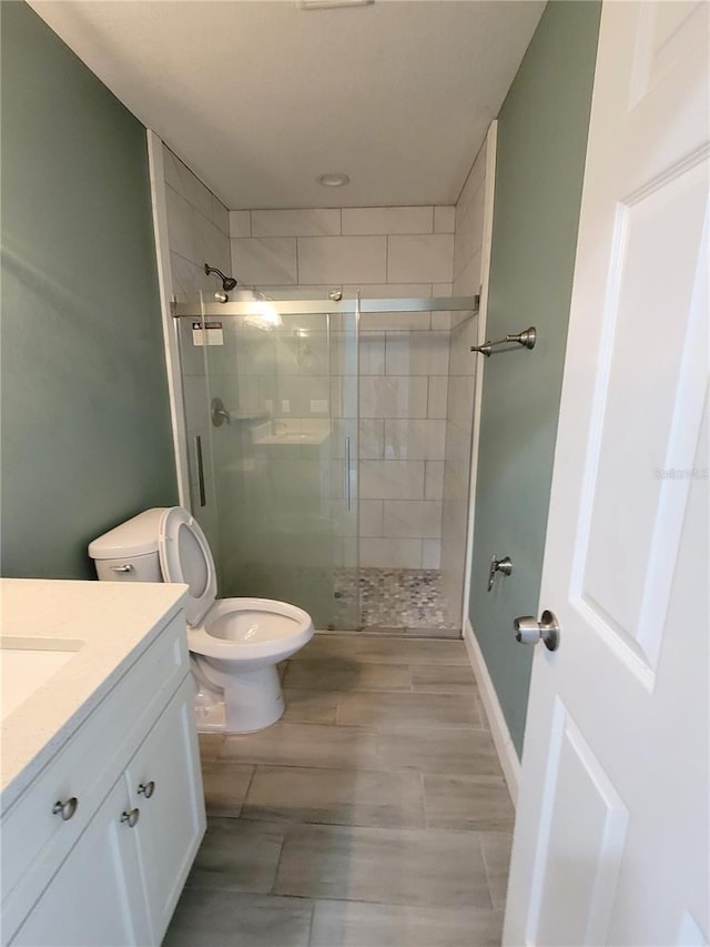 bathroom with vanity, an enclosed shower, and toilet