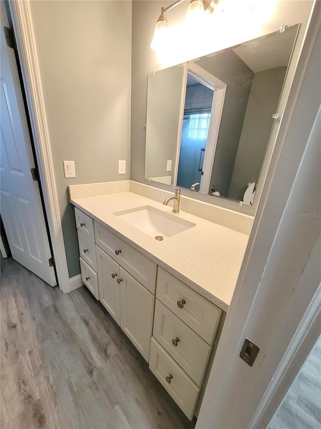 bathroom with vanity, hardwood / wood-style floors, and toilet