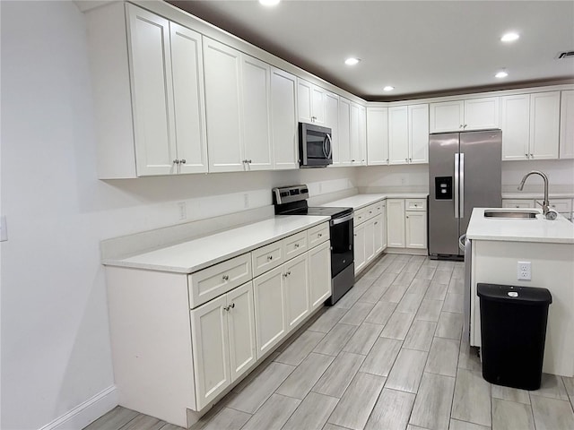 kitchen with sink, white cabinets, and appliances with stainless steel finishes