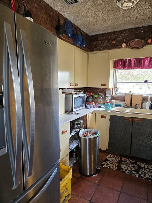 kitchen featuring stainless steel appliances, sink, and a textured ceiling