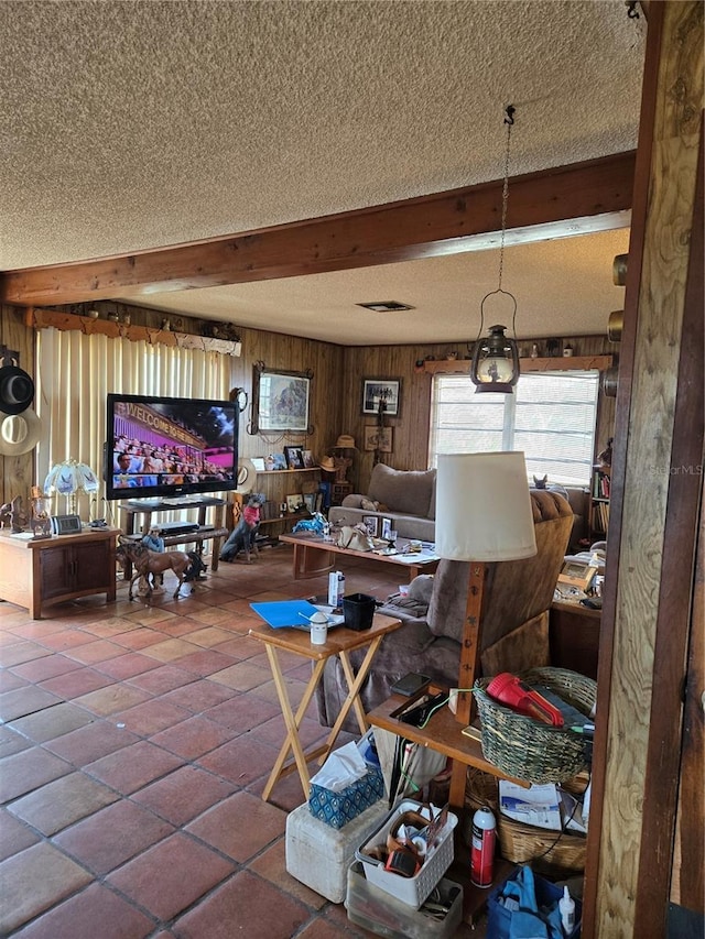 dining space featuring beamed ceiling, a textured ceiling, and wood walls