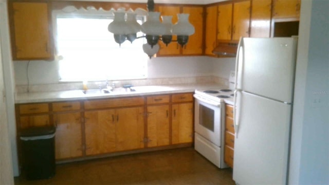 kitchen with sink, an inviting chandelier, white appliances, and range hood