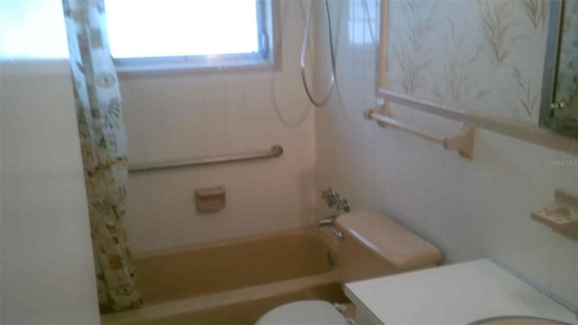 full bathroom with vanity, shower / tub combo, and toilet