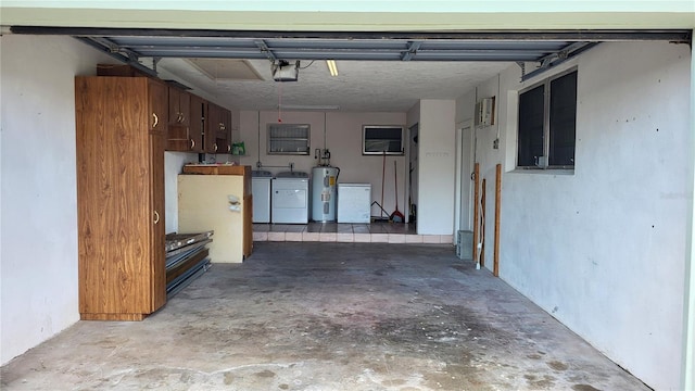 garage featuring water heater, washer and dryer, and a garage door opener