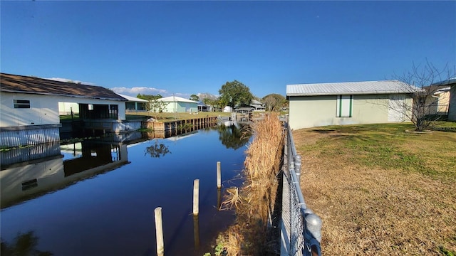 dock area with a yard and a water view