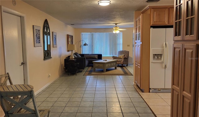 tiled living room featuring ceiling fan and a textured ceiling