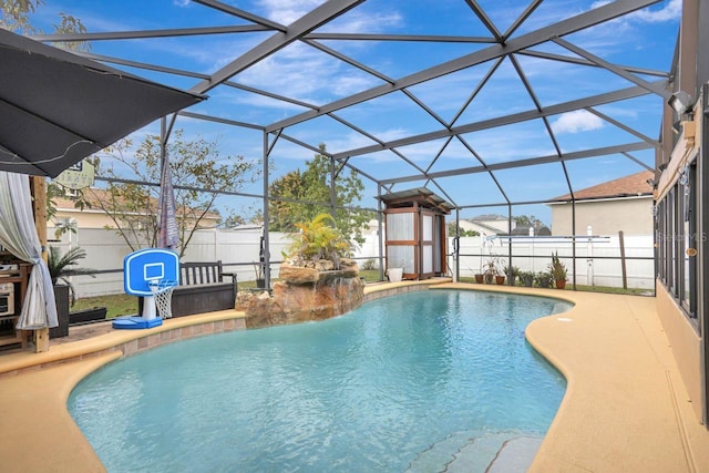 view of swimming pool with glass enclosure, a patio area, a fenced backyard, and a fenced in pool