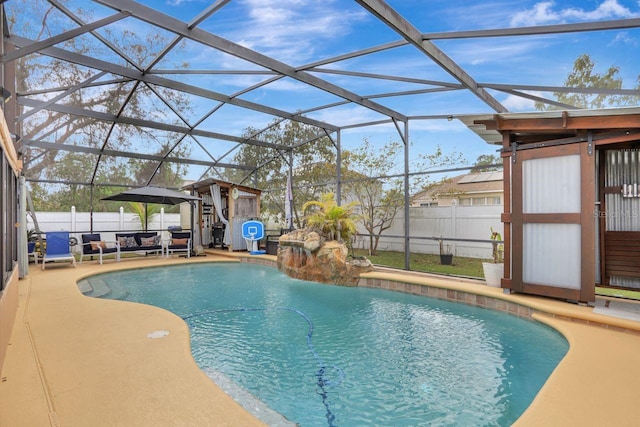 view of pool with glass enclosure, a fenced backyard, and a fenced in pool