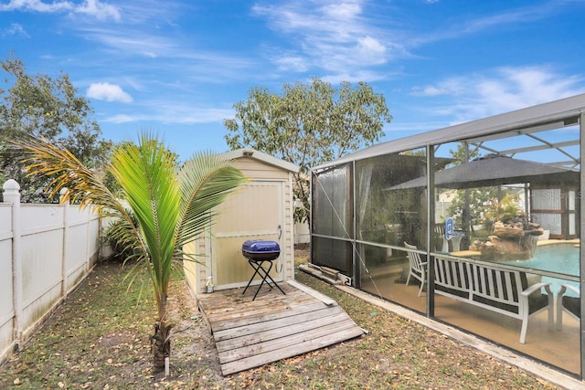 view of yard with a lanai, a fenced backyard, an outdoor pool, and a shed