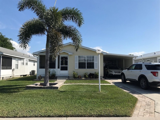 view of front of home with central AC, a carport, and a front lawn