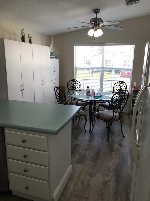 dining space with dark wood-type flooring and ceiling fan