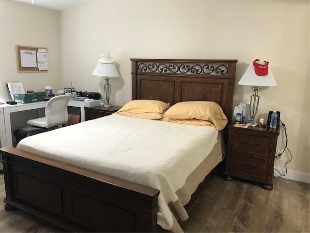 bedroom with dark hardwood / wood-style floors and built in desk