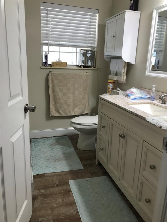 bathroom featuring vanity, wood-type flooring, and toilet