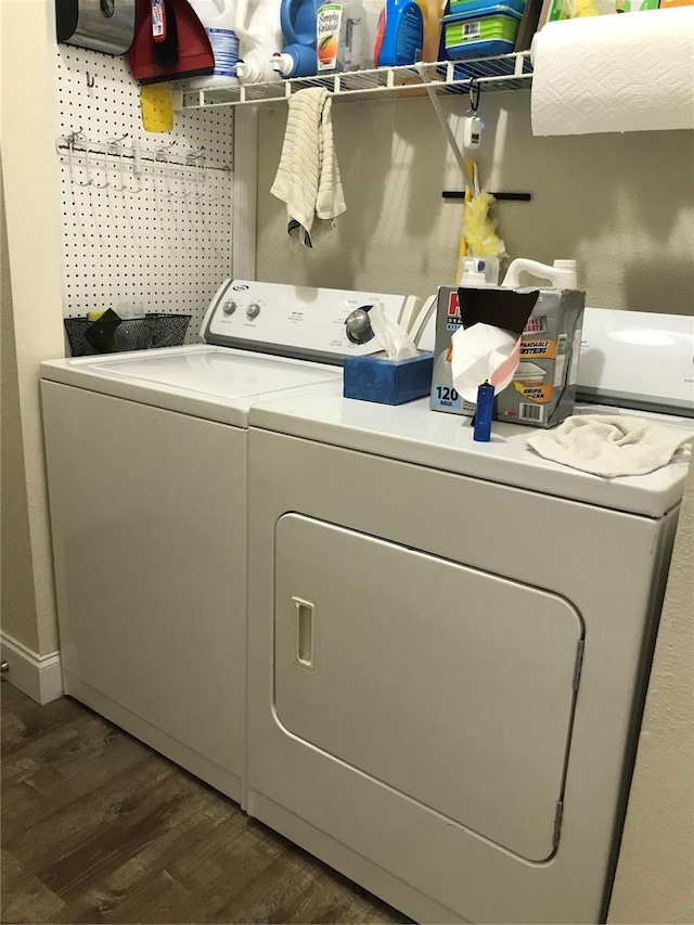 clothes washing area with dark hardwood / wood-style floors and washer and clothes dryer