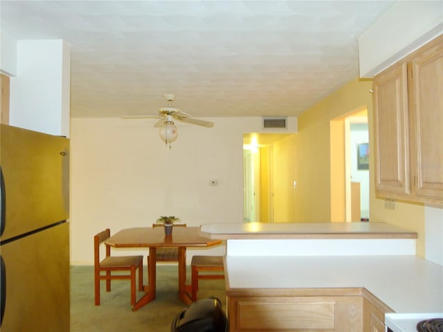 kitchen featuring fridge, light brown cabinets, and ceiling fan