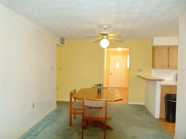 dining area featuring light colored carpet and ceiling fan