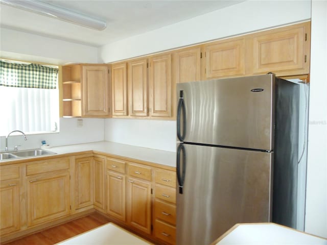 kitchen featuring stainless steel fridge, light hardwood / wood-style floors, sink, and light brown cabinets