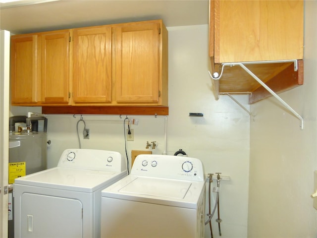 clothes washing area with separate washer and dryer, electric water heater, water heater, and cabinets