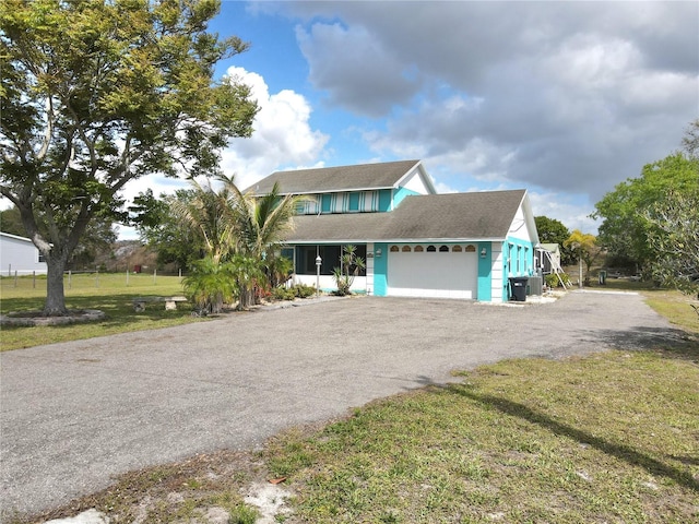 view of front of property with a garage, driveway, and a front lawn