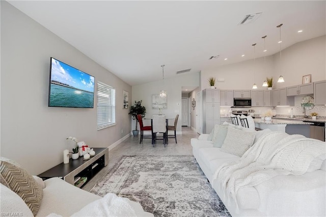 living room featuring high vaulted ceiling, baseboards, visible vents, and recessed lighting