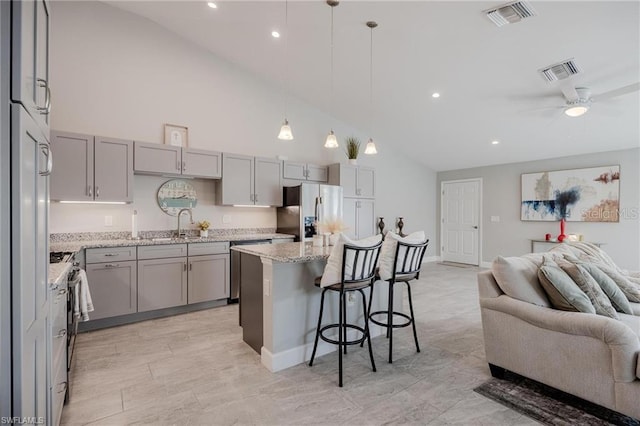 kitchen featuring open floor plan, visible vents, refrigerator with ice dispenser, and gray cabinetry