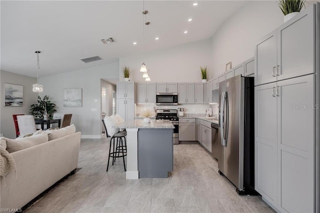 kitchen featuring stainless steel appliances, a breakfast bar, open floor plan, and visible vents