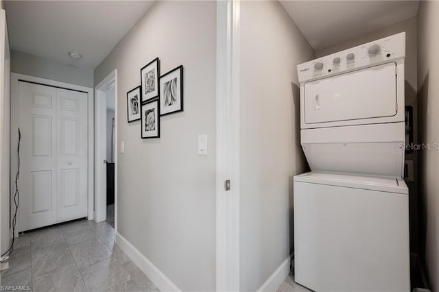 washroom featuring stacked washing maching and dryer, baseboards, laundry area, and marble finish floor