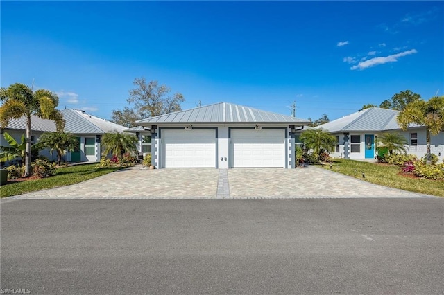 ranch-style house featuring metal roof and decorative driveway