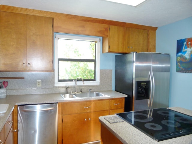 kitchen with appliances with stainless steel finishes, light countertops, brown cabinets, and a sink