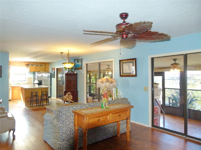 living room with a healthy amount of sunlight, a textured ceiling, and wood finished floors