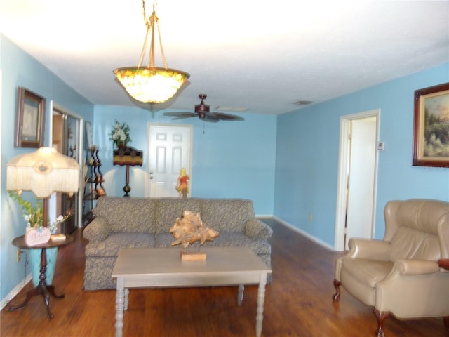 living room featuring baseboards, visible vents, ceiling fan, and wood finished floors