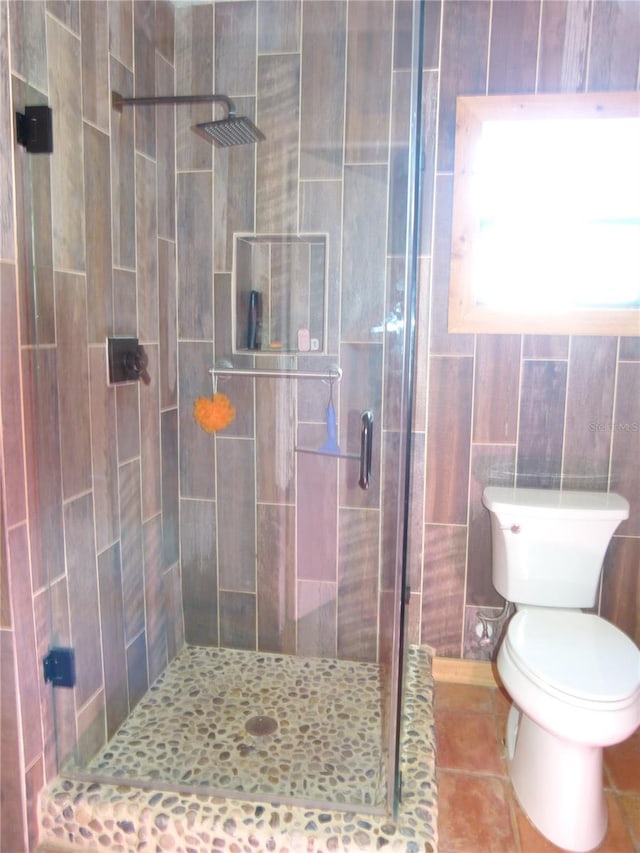 full bathroom with toilet, a shower stall, and tile patterned floors