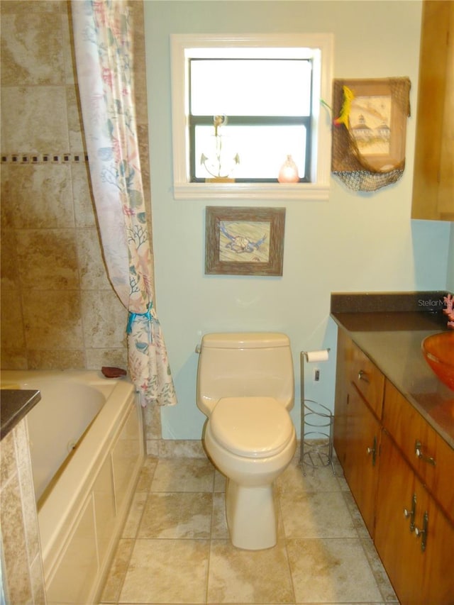 bathroom with tiled shower / bath combo, vanity, and toilet