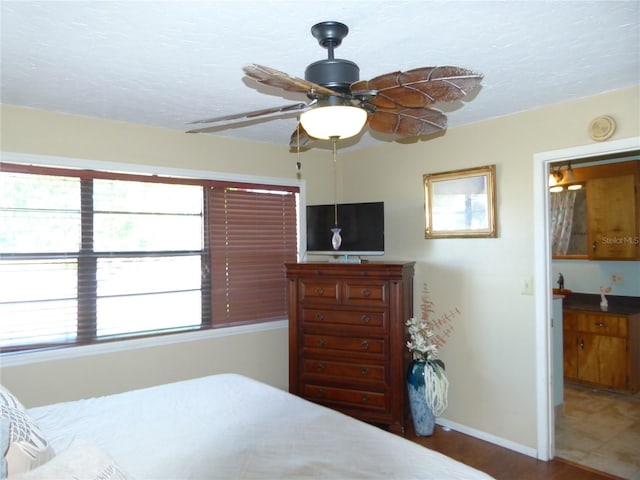 bedroom with a textured ceiling, a ceiling fan, and baseboards