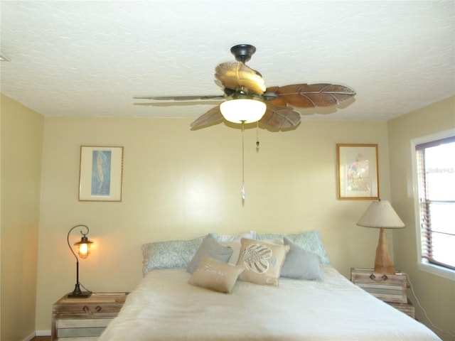 bedroom with a ceiling fan and a textured ceiling