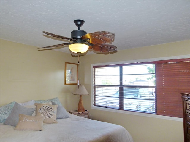 bedroom featuring a ceiling fan and a textured ceiling