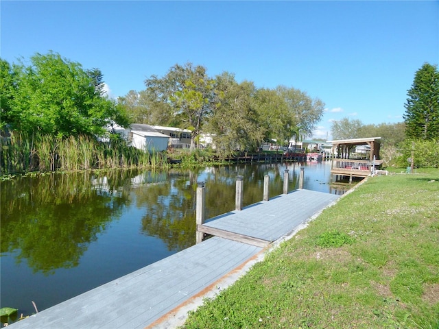 view of dock featuring a yard and a water view